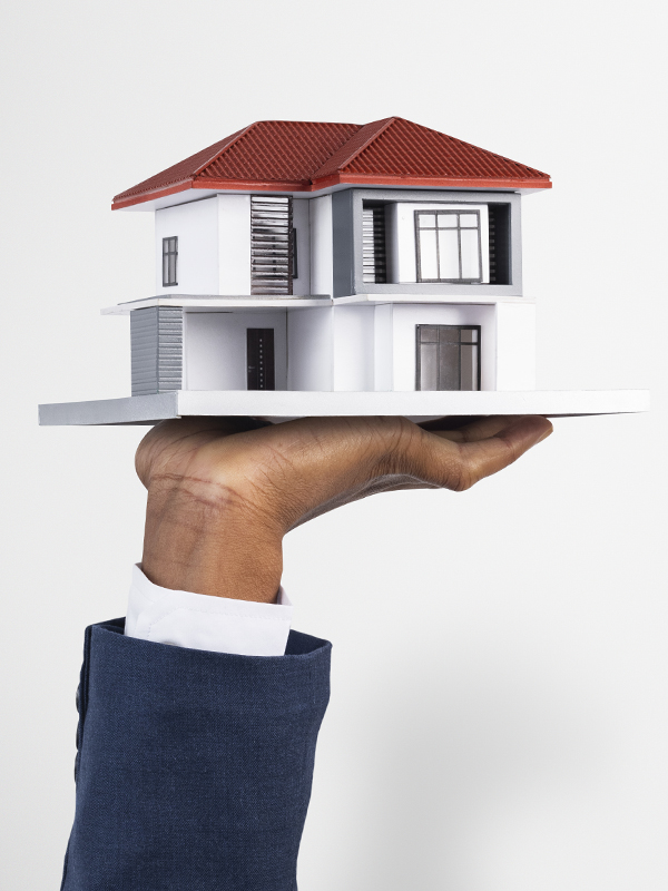 Hand holding house real estate and property model